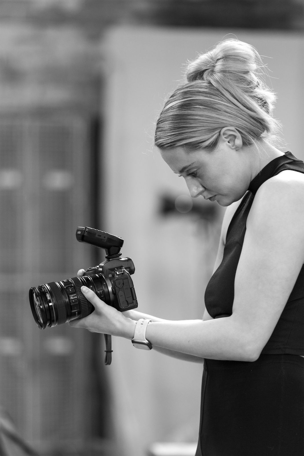 Victoria checking shots on her camera, black and white