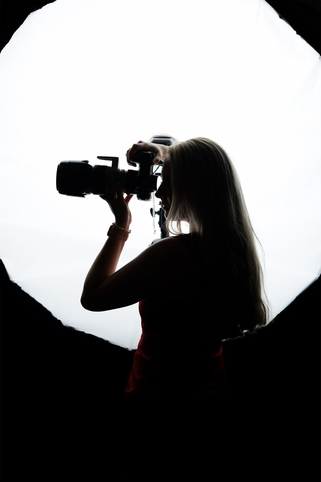 Silhouette of Victoria shooting in front of a large softbox