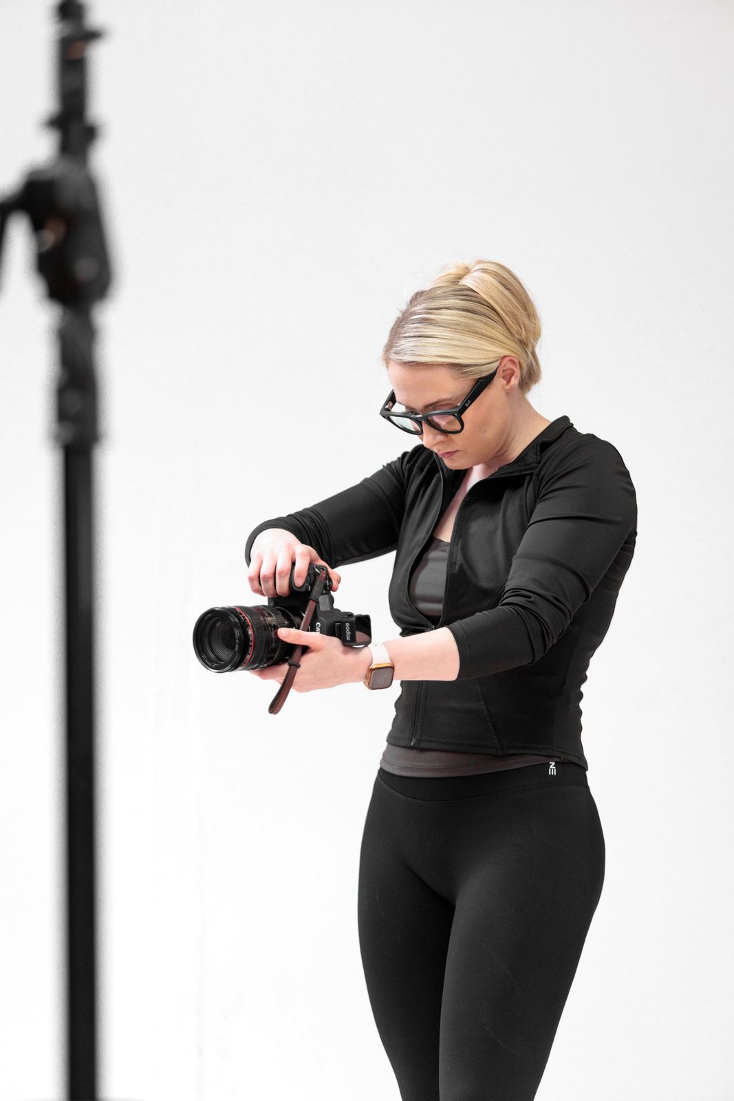 Victoria adjusting camera settings in the studio